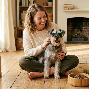 woman with Miniature Schnauzer surrounded by eco-friendly dog products